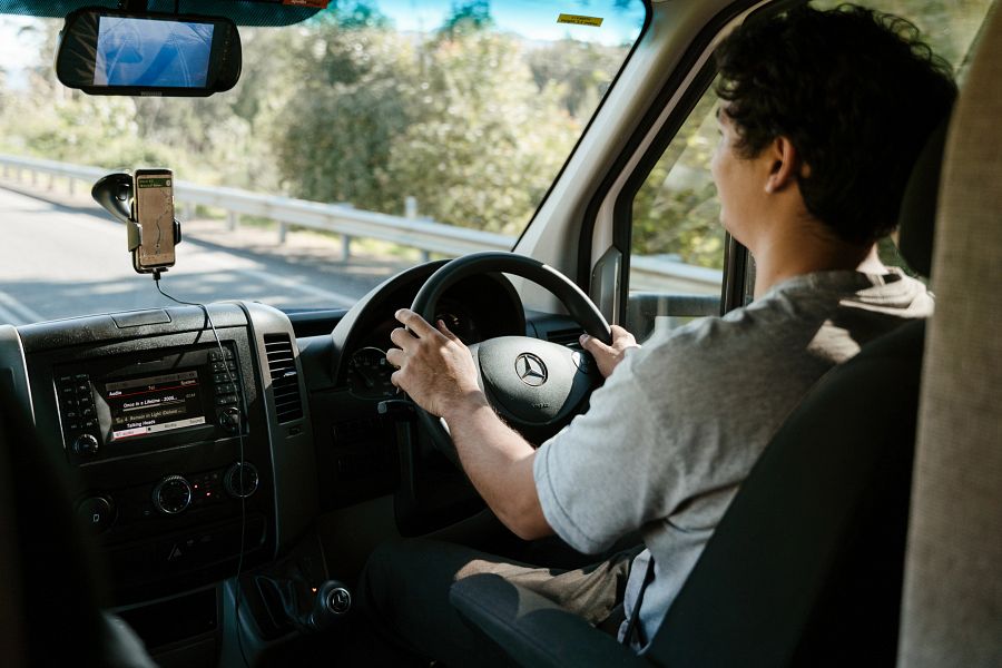 Man rijdt in Mighty camper en kijkt over de weg