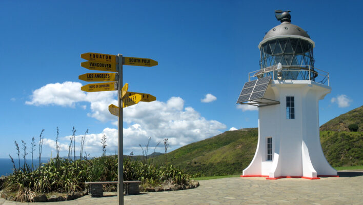 Zicht op de vuurtoren bij Cape Reinga en een richtingaanwijzer
