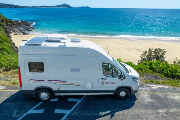 Zijaanzicht van de Cruisin' Rover camper geparkeerd aan het strand