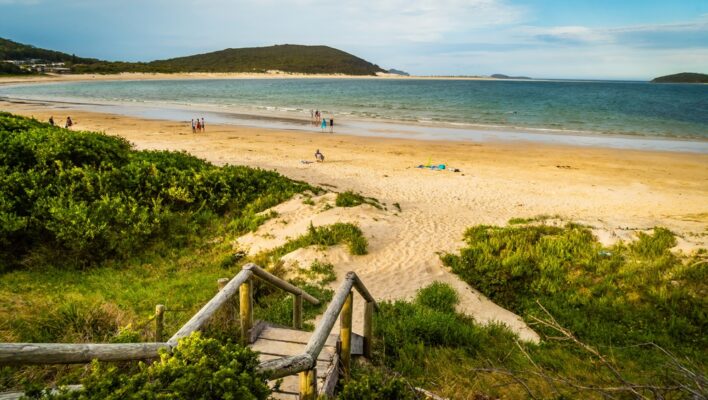 Zicht op het strand van Port Stephens vanaf een trap naar beneden