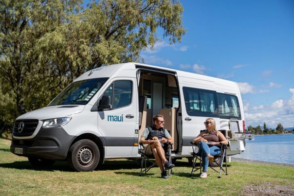 Koppel zit in campingstoelen voor de Maui Ultima met de zijdeur open
