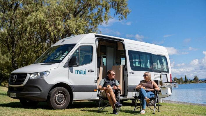 Koppel zit in campingstoelen voor de Maui Ultima met de zijdeur open