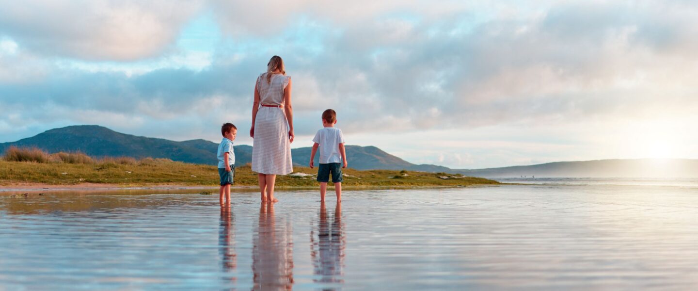 Moeder loopt met jonge kinderen over het strand in Australië