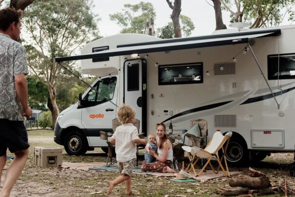 Vader loopt met kind af op moeder met kind die voor de Apollo Euro Camper op de grond zitten