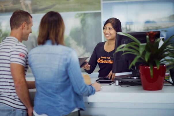 Stel staat aan de balie in gesprek met een medewerker om een camper op te halen