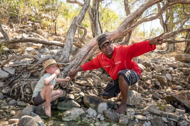 Aboriginal wijst iets aan in de natuur voor kind