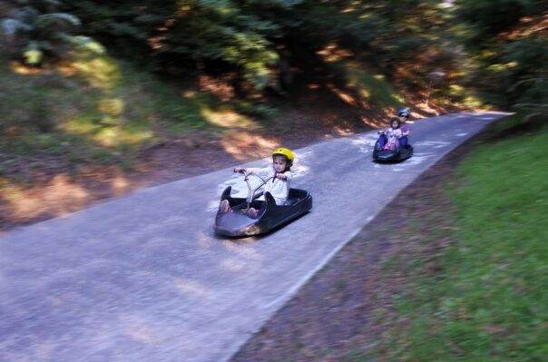 Kinderen gaan in luge naar beneden op baan in Rotorua