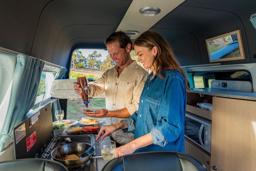 Een koppel is aan het koken in de Apollo Endeavour camper in Australië