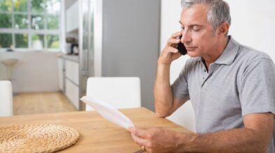 Man belt over offerte thuis aan de keukentafel