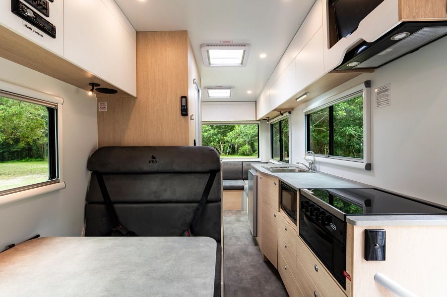 Het interieur van de Maui Beach camper vanaf de bestuurdersruimte kijkend naar de achterkant van de camper waar de keuken en de zithoek is
