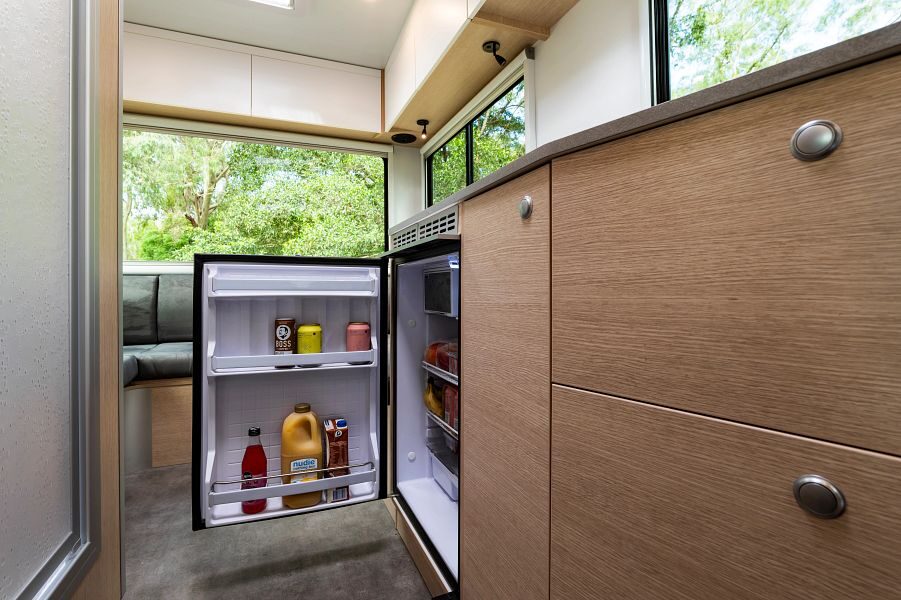 Een open koelkast met pakken drinken in de keuken van de Maui Beach camper