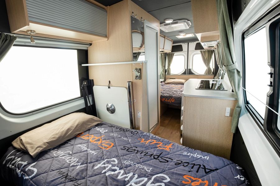 Het interieur met een eenpersoonsbed voorin en een tweepersoonsbed achterin de Mighty Deuce Plus camper