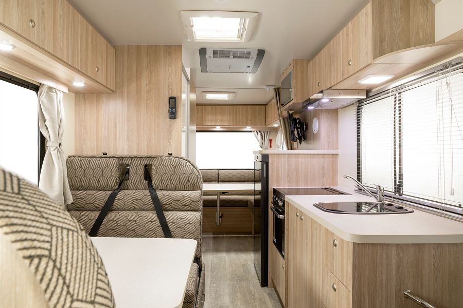 Het interieur met zitplaatsen in het midden, keuken en een zithoek achter de Mighty Double Up camper