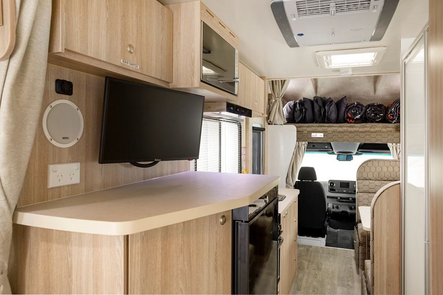 Het interieur van de voorkant van de Mighty Double Up camper met TV