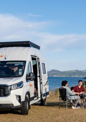 Toeristen zitten in campingstoelen bij Britz Voyager op het Noordereiland