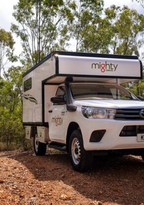 De voorkant van de Mighty 4WD camper die rijdt over een onverharde weg in Australië