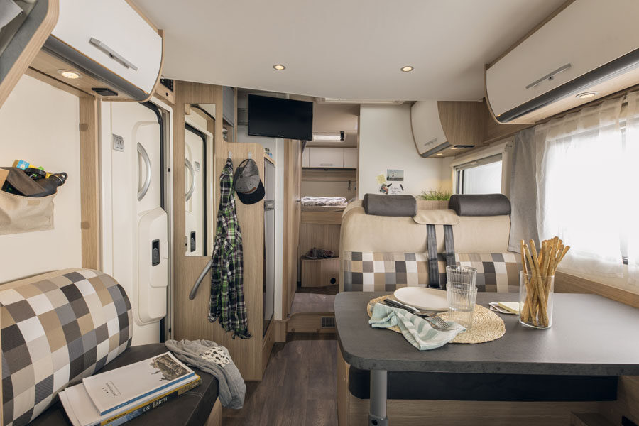 Het interieur kijkend van voor naar achter met de zithoek van de McRent Comfort Luxury