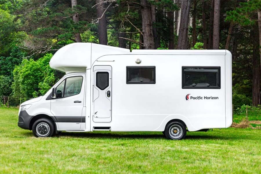 De Pacific Horizon Gem 4 camper staat geparkeerd op het gras vanaf de zijkant gezien