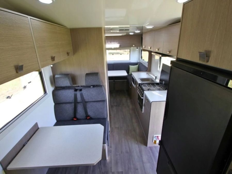 Koelkast, dinette, keuken en zithoek achter van de Leisure Rent Deluxe Motorhome