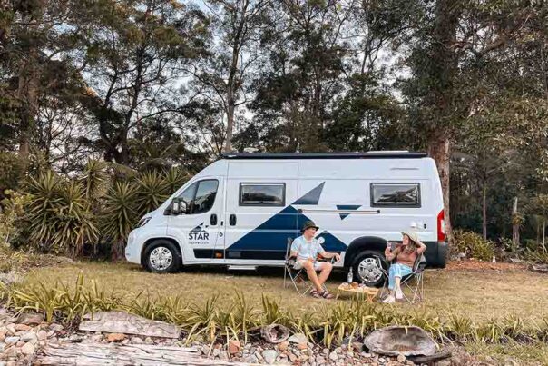 Een stel heeft de Star RV Polaris 2 camper geparkeerd op een kampeerplaats en zit voor de camper
