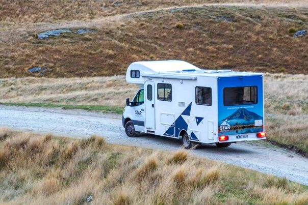 De Star RV Polaris 6 staat geparkeerd op een grindweg in de natuur van Nieuw-Zeeland