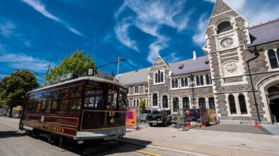 Tram rijdt langs oud gebouw in Christchurch Nieuw-Zeeland