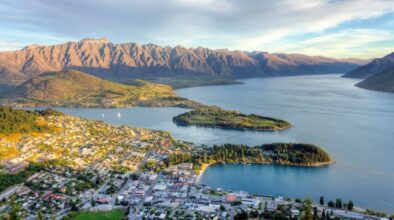 Uitzicht van bovenaf op Queenstown en Lake Wakatipu omringd door hoge bergen