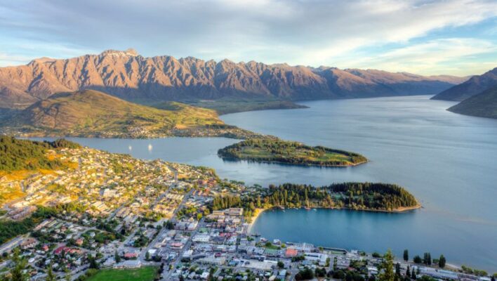 Uitzicht van bovenaf op Queenstown en Lake Wakatipu omringd door hoge bergen
