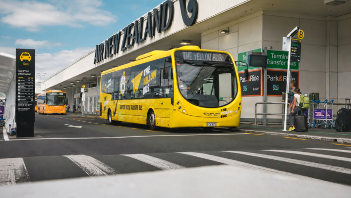 De Yellow Bus staat geparkeerd voor de luchthaven in Auckland