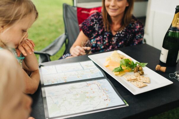 Familie kijkt op routekaart aan campingtafel