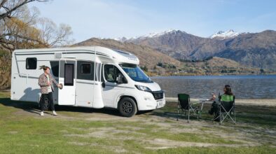 Een stel is aan het wild kamperen met de Britz Odyssey aan een meer