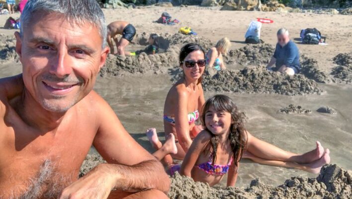 Gezin heeft gat gegraven op hot water beach op Coromandel peninsula
