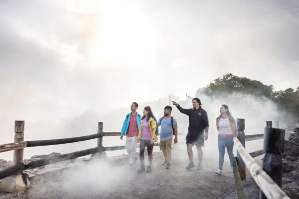 Maori geeft rondleiding aan toeristen bij Te Puia in Rotorua