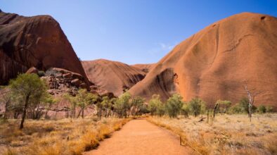 Zicht op Uluru-Ayers-Rock in het Red Centre vanaf een gravelweg