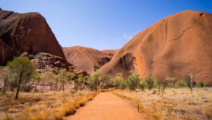 Zicht op Uluru-Ayers-Rock in het Red Centre vanaf een gravelweg