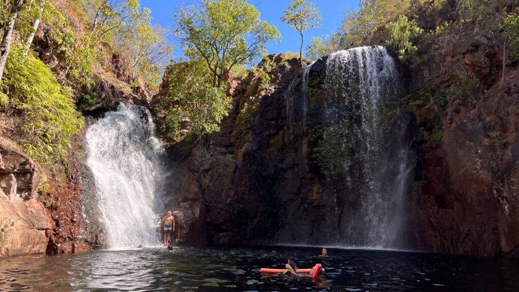 Mensen zwemmen in de waterpoel bij de Florence Falls in Litchfield